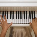 a person's hands on a piano keyboard